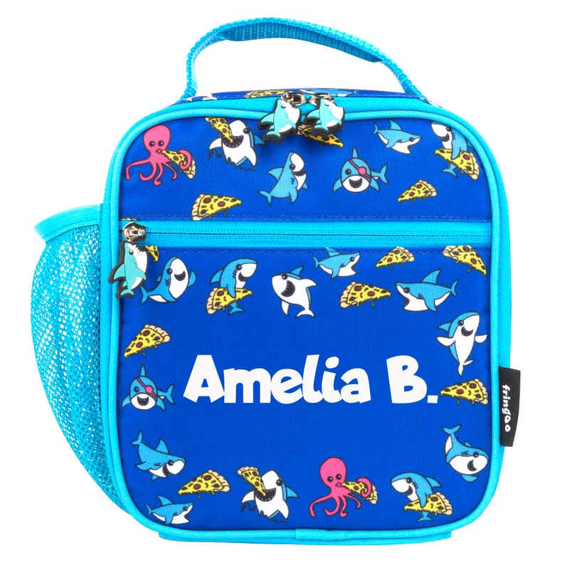 May include: Blue lunch bag with a shark and pizza print. The bag has a mesh side pocket and a zipper closure. The bag is personalized with the name "Amelia B."