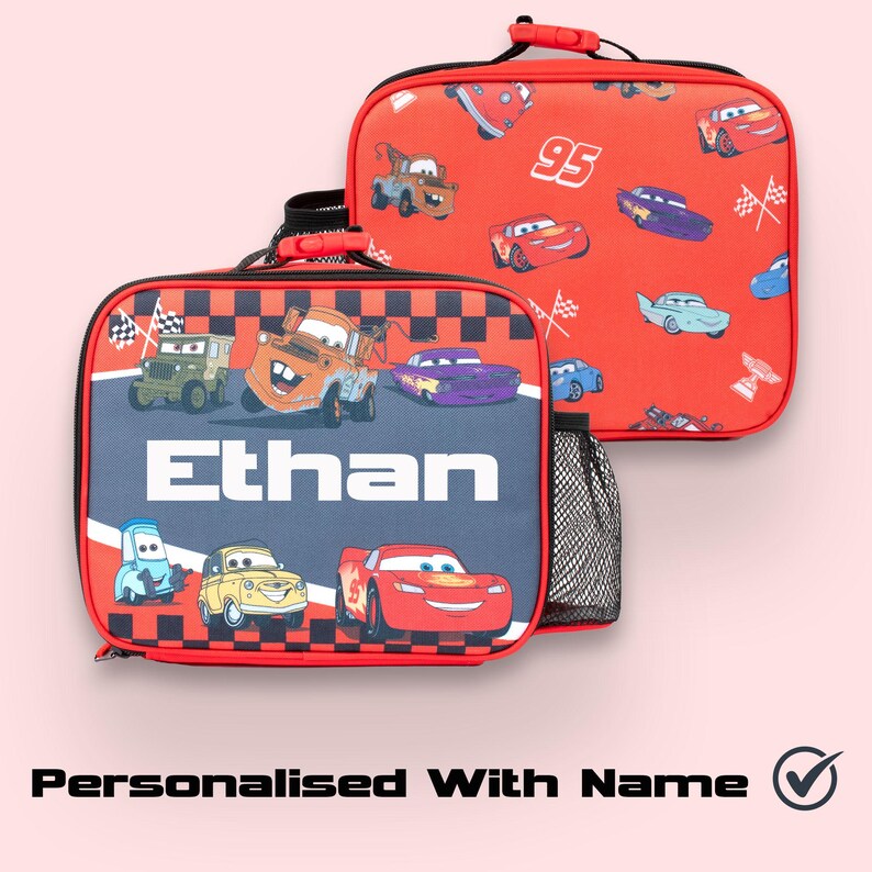Pode incluir: Duas lancheiras vermelhas e pretas com tema Cars. Uma bolsa apresenta uma borda quadriculada e o nome "Ethan" em branco. A outra bolsa tem um fundo vermelho com v&aacute;rias ilustra&ccedil;&otilde;es de carros. Ambas as bolsas t&ecirc;m um bolso lateral de malha preta e uma al&ccedil;a vermelha.