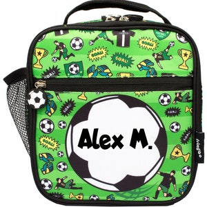 May include: Green lunch bag with a soccer ball design. The bag has a black zipper and a mesh side pocket. The soccer ball has the name "Alex M." written on it.