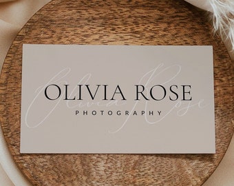 May include: A light brown wooden coaster with a beige business card on top. The business card has the text "Olivia Rose Photography" in black font.