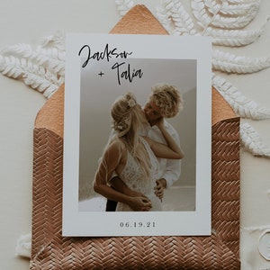 May include: A wedding invitation with a photo of a couple kissing. The invitation is white with black text that says "Jackson + Talia" and "06.19.21".