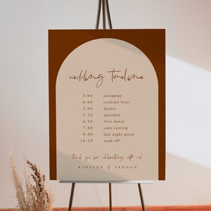 May include: A brown and beige wedding timeline sign with an arch shape at the top. The sign lists the wedding events and times, including the ceremony, cocktail hour, dinner, speeches, first dance, cake cutting, late night pizza, and send off. The sign is on an easel and has the names Kinsley and Teegan at the bottom.