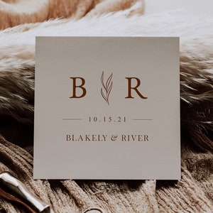 May include: A wedding logo design with the initials "B" and "R" in brown text with a stylized leaf design between the letters. The text "10.15.21" and "BLAKELY & RIVER" are also in brown text.