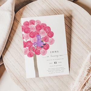 Op de afbeelding: Een roze en witte verjaardagsuitnodiging met een paarse aap die op een boom zit. De uitnodiging luidt "Emma wordt één" en bevat de datum en tijd van het feest.