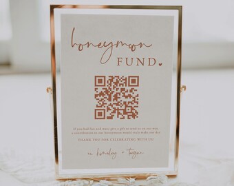 Könnte beinhalten: Ein Schild mit goldenem Rahmen und weißem Hintergrund. Das Schild trägt die Aufschrift "honeymoon fund" und einen QR-Code. Der Text unter dem QR-Code lautet "Wenn Sie Spaß hatten und uns ein Geschenk für unsere Reise schenken möchten, wäre ein Beitrag zu unseren Flitterwochen wirklich schön. Vielen Dank, dass Sie mit uns feiern!" und ist mit "finsley + tugan" signiert.