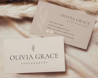 May include: Two beige business cards with a simple floral design and the text "Olivia Grace Photography" on them. The top card includes contact information, including a phone number, email address, website, and social media handle.