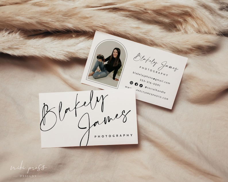 May include: Two business cards with the name "Blakely James Photography" in a handwritten font. The top card has a photo of a woman holding a camera. The bottom card has the name in a larger font.