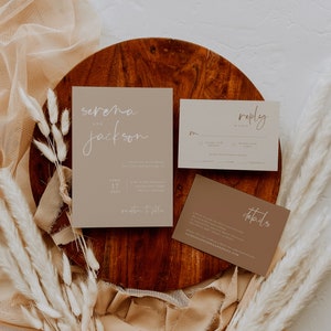 Puede incluir: Un conjunto de tres tarjetas de invitaci&oacute;n de boda con un tema r&uacute;stico. Las tarjetas son beige y marr&oacute;n con texto en caligraf&iacute;a blanca. La tarjeta principal dice "Serena y Jackson" con la fecha "17 de abril de 2021" y la ubicaci&oacute;n "Recepci&oacute;n a continuaci&oacute;n". La segunda tarjeta dice "Respuesta" y tiene un espacio para que los invitados respondan. La tercera tarjeta dice "Detalles" e incluye informaci&oacute;n sobre la boda.