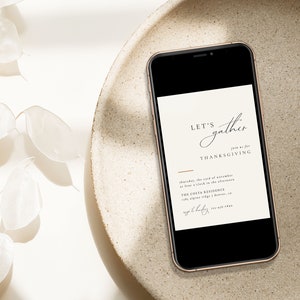 Puede incluir: Un tel&eacute;fono inteligente que muestra una invitaci&oacute;n a la cena de Acci&oacute;n de Gracias con el texto "Let's gather... for Thanksgiving" y detalles sobre el evento. La invitaci&oacute;n est&aacute; sobre un fondo blanco.
