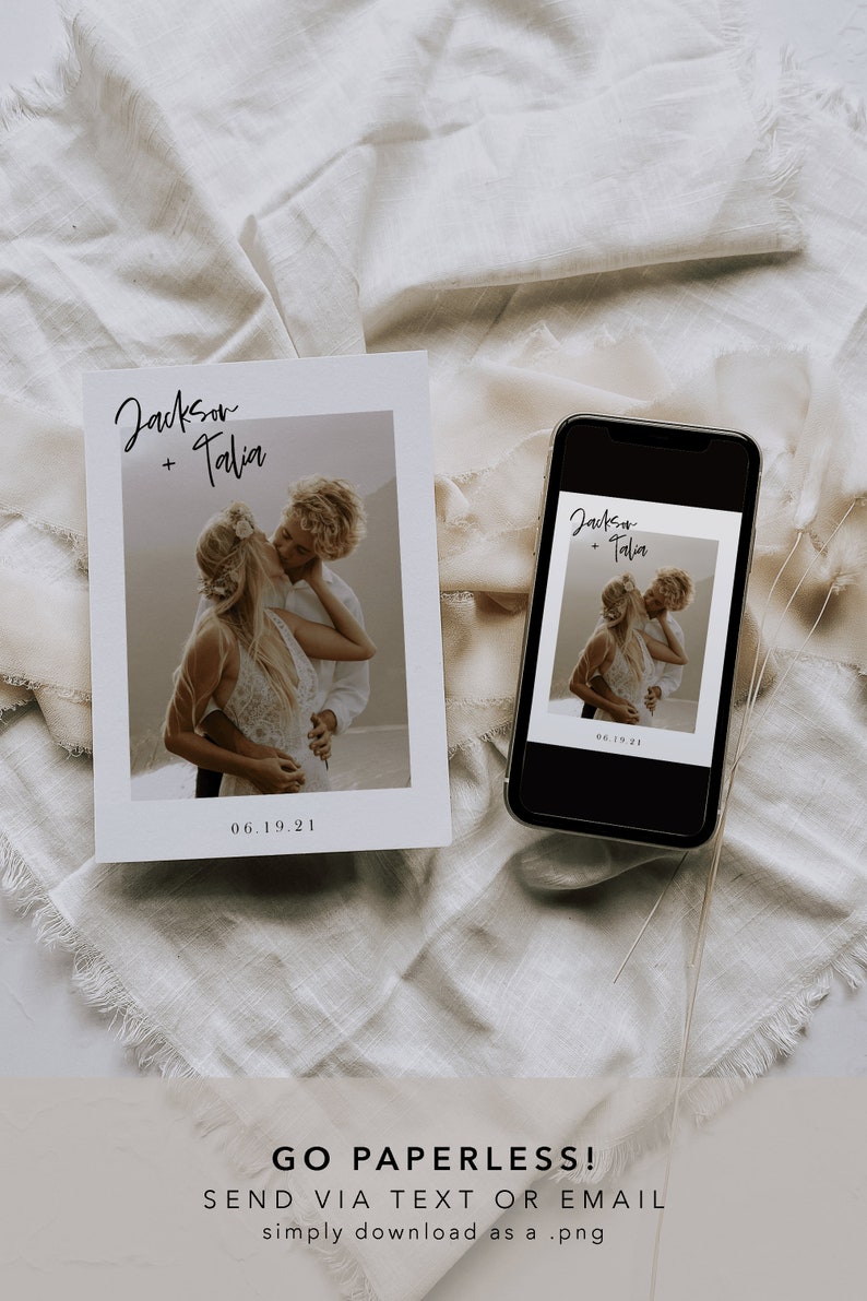 May include: A white card with a photo of a couple kissing. The card has the text "Jackson + Talia" and "06.19.21" printed on it. A smartphone with a similar photo and text is lying on a white fabric surface.