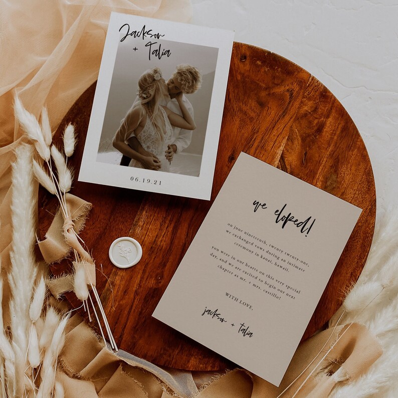 May include: A wedding announcement card with a photo of a couple kissing. The card is beige with black text that reads "we eloped!" and "Jackson + Talia".