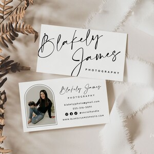 May include: White business card with black text. The text reads "Blakely James Photography" and includes contact information for the photographer. A photo of the photographer is in the corner of the card.