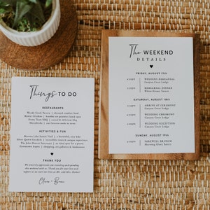 May include: A white card with black text listing things to do in Aspen, Colorado, including restaurants, activities, and fun. The card also includes a thank you message and the names Olivia and Bran. A second white card with black text lists the weekend details for a wedding, including the date, time, and location of the wedding rehearsal, ceremony, and reception.