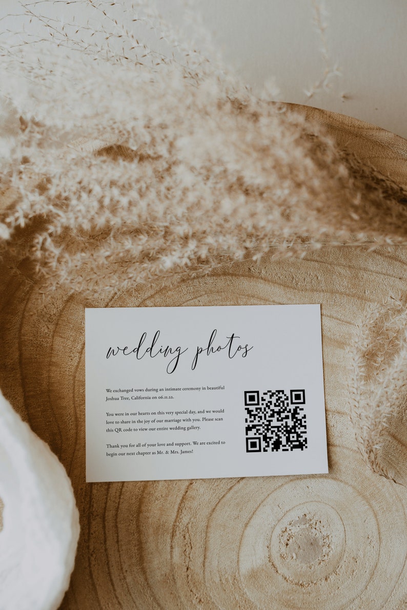 May include: A white card with the text "wedding photos" in black cursive script. The card includes a QR code and the text "We exchanged vows during an intimate ceremony in beautiful Joshua Tree, California on 06.11. You were in our hearts on this very special day, and we would love to share in the joy of our marriage with you. Please scan this QR code to view our entire wedding gallery. Thank you for all of your love and support. We are excited to begin our next chapter as Mr. & Mrs. James!"