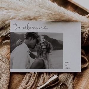 Puede incluir: Una tarjeta de anuncio de boda con una foto en blanco y negro de una pareja bes&aacute;ndose. La tarjeta tiene el texto "The Williamsons" y "Best. Day. Ever." impreso en ella.