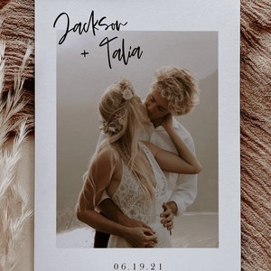 May include: A wedding invitation with a photo of a couple kissing. The invitation is white with black text that reads "Jackson + Talia" and "06.19.21".