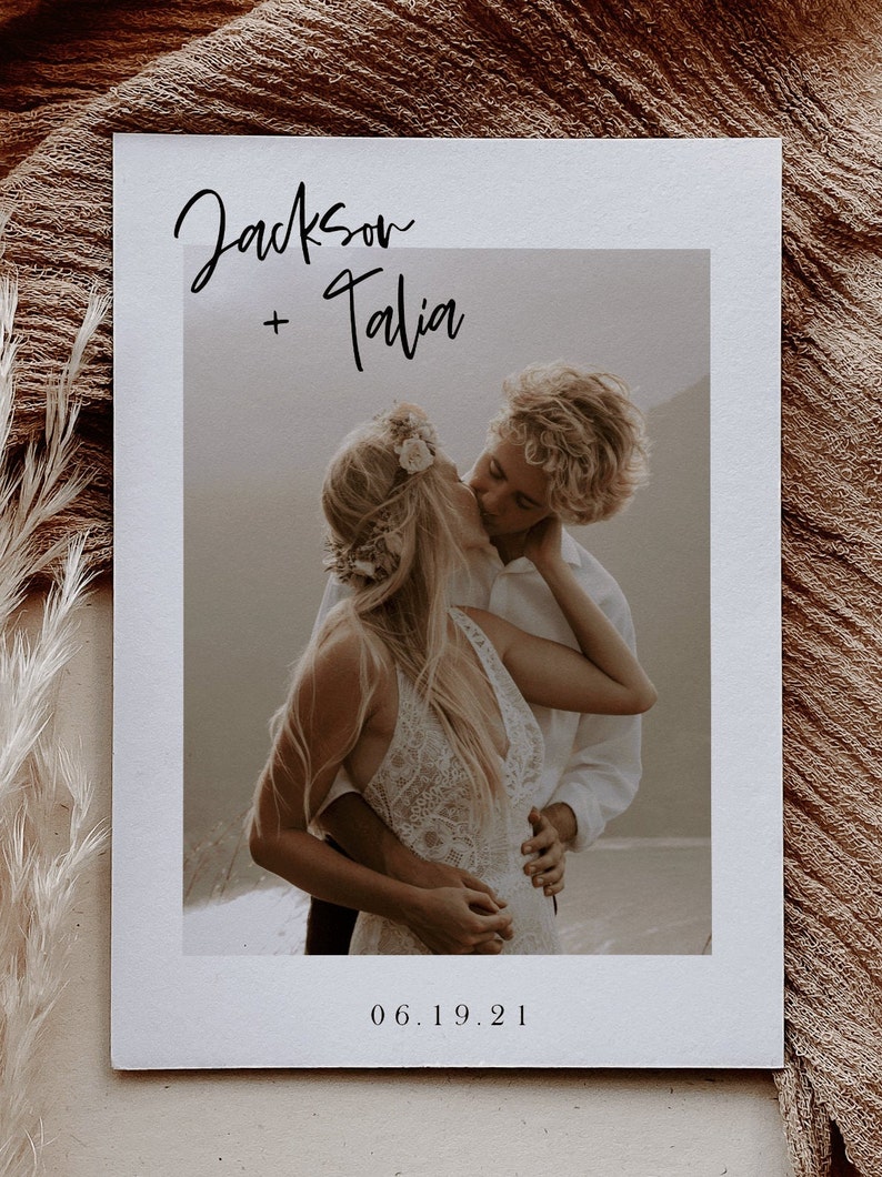 May include: A wedding invitation with a photo of a couple kissing. The invitation is white with black text that reads "Jackson + Talia" and "06.19.21".