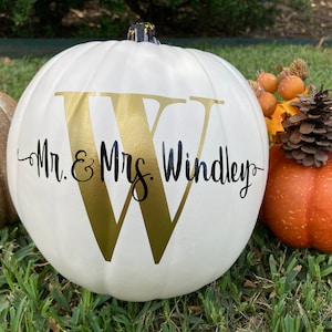 May include: White pumpkin with a gold letter W and the text "Mr. & Mrs. Windley" in black lettering.