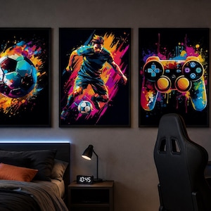 Puede incluir: Tres láminas rectangulares para pared con diseños vibrantes de salpicaduras de pintura multicolor. La lámina izquierda muestra un balón de fútbol, la central un jugador en movimiento y la derecha un mando de videojuegos.