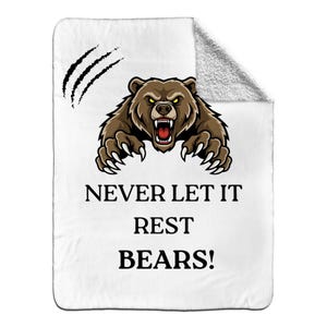 May include: White blanket with a brown bear graphic and the text "NEVER LET IT REST BEARS!". The bear has an angry expression with its mouth open and claws extended. Black claw marks are in the upper left corner.