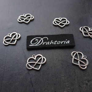 Könnte beinhalten: Sechs silberne Unendlichkeits-Herz-Anhänger mit einem schwarzen Etikett mit der Aufschrift "Drahtoria".