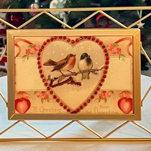 Joyeuse Saint-Valentin ! Deux adorables oiseaux dans un coeur en strass rouge. Carte de Saint-Valentin haut de gamme, unique en son genre, encadrée. Cadre en métal doré