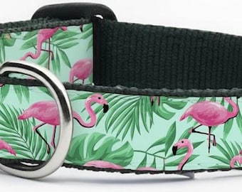 May include: A dog collar featuring a tropical flamingo design. The collar has a black buckle and a silver metal loop. The pattern includes pink flamingos and green tropical leaves on a light green background.