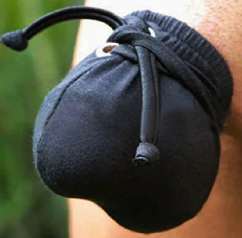 May include: A black fabric pouch with a drawstring closure. The pouch is made of a soft, stretchy material and has a round shape.