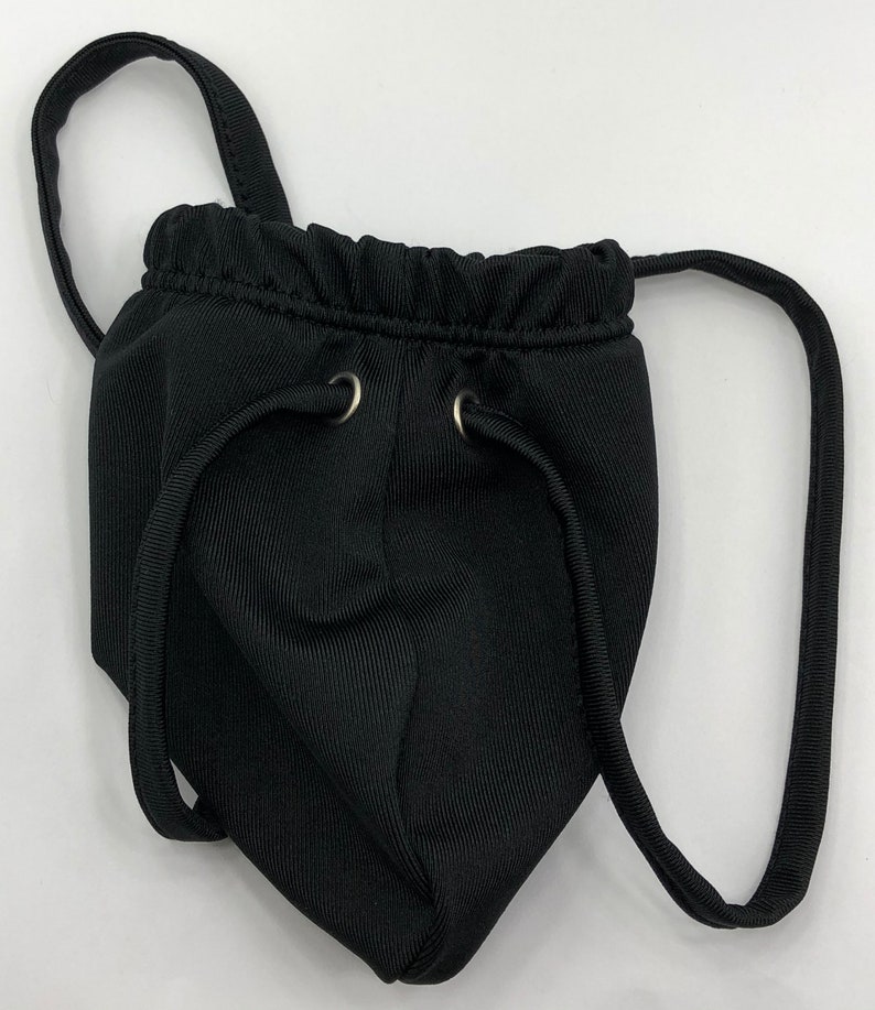 May include: Black pouch with a drawstring closure and two adjustable straps. The pouch has a ribbed texture and two silver metal eyelets.