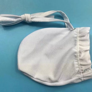 May include: White drawstring bag made of a soft, stretchy fabric. The bag has a white drawstring closure and a small metal ring.
