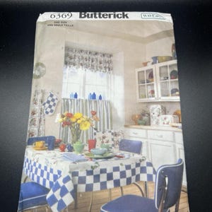 May include: A vintage Butterick sewing pattern envelope featuring a kitchen scene. The image shows a checkered tablecloth, blue chairs, and matching curtains. The text "6369 Butterick" is visible at the top. The kitchen is decorated with floral accents and a vase of flowers.