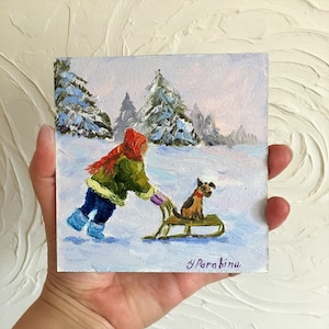 May include: A painting of a child in a red hat and green coat pulling a sled with a small brown dog on it through a snowy winter landscape. The painting is signed "Y.Parabina".