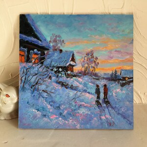 May include: A painting of a snowy winter scene with two figures walking in the distance. The painting features a small wooden house with a lit window, a snow-covered landscape, and a colorful sky with a hint of pink and orange.