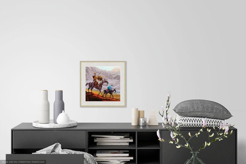 May include: A framed painting of two figures on horseback riding through a desert landscape. The figures are wearing traditional clothing and the horses are brown. The background is a muted brown and gray.