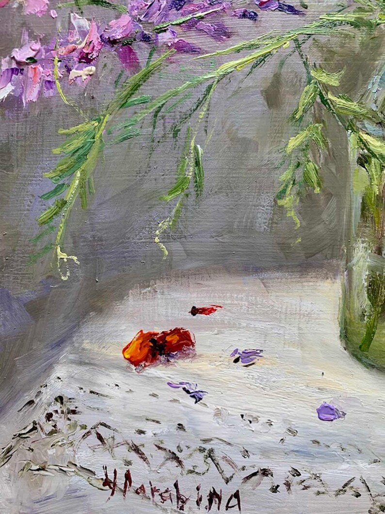 May include: An impressionistic painting of a floral still life. The artwork features vibrant purple and pink flowers with green stems in a clear glass vase. Scattered petals and a red-orange object rest on a white surface.