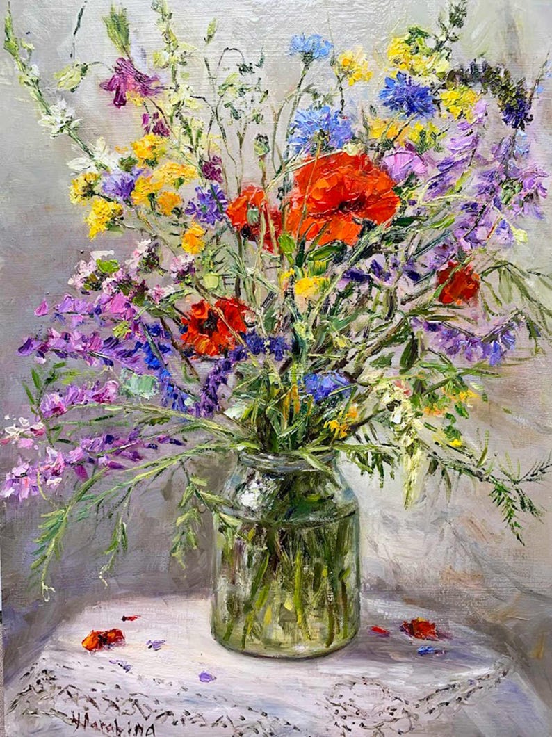May include: A vibrant oil painting of a wildflower bouquet in a clear glass jar. The arrangement features red poppies, purple, yellow, and blue wildflowers. The jar sits on a white lace-covered surface against a gray backdrop. The artist's signature is visible.