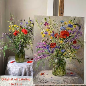 May include: Original oil painting of a vibrant floral arrangement in a glass jar, featuring red poppies, purple, yellow, and blue wildflowers. The artwork is 16x12 inches on a panel, displayed on an easel and table with a lace tablecloth.