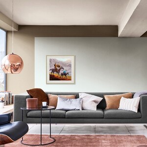 May include: A living room with a gray sofa, a copper pendant light, and a framed painting of two people on horseback. The room has a large window with a view of a city skyline.