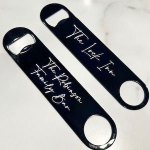May include: Two black metal bottle openers with white text. The top opener says "The Lock Inn" and the bottom opener says "The Robinson Family Bar".