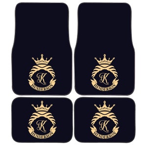 Puede incluir: Conjunto de cuatro alfombrillas de coche negras con una corona dorada y la letra K en un círculo con la palabra HENDERSON debajo.