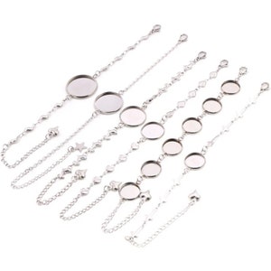 Puede incluir: Seis pulseras de cadena plateadas con engastes redondos de cabujón de vidrio. Las cadenas presentan diferentes encantos, incluyendo corazones, estrellas y medias lunas.