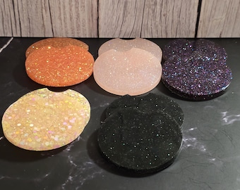 May include: Six round, flat, glitter-covered coasters in various colors, including orange, pink, black, and iridescent.