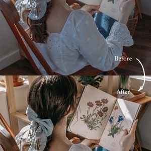 May include: A woman wearing a white blouse with embroidered details sits in a wooden chair and reads a book with botanical illustrations. She has a light blue bow in her hair.