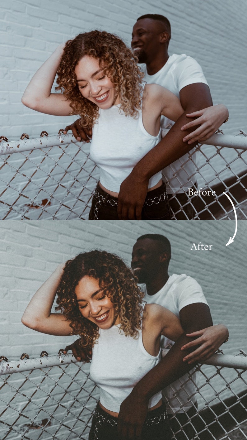 May include: A couple poses in front of a white brick wall. The woman is wearing a white tank top and black pants with a silver chain belt. The man is wearing a white t-shirt. They are both smiling and laughing. The couple is standing in front of a chain link fence.