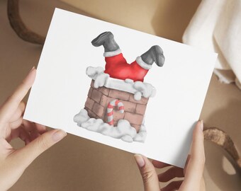 May include: A greeting card featuring an illustration of Santa Claus stuck in a chimney. Santa's red suit and black boots are visible, with a brick chimney and candy cane. The card is held by hands.