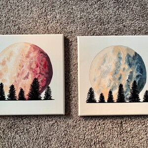 May include: Two paintings on canvas featuring a large, full moon with a silhouette of a forest of trees in the foreground. The moon on the left is a reddish-brown color, while the moon on the right is a blue-grey color.