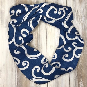May include: A blue and white fabric headband with a swirling pattern. The headband is made of a soft, comfortable material and is perfect for adding a touch of style to any outfit.