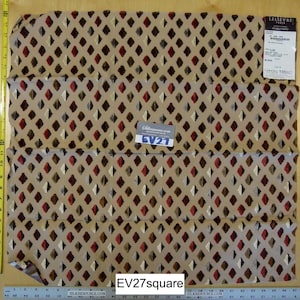Puede incluir: Una tela beige con un patrón repetido de rombos marrones, rojos y blancos. La tela está doblada en tres partes y tiene una pequeña etiqueta con el texto "EV27". La tela está etiquetada como "Lellievre Paris" y "Tissus d'ameublement".