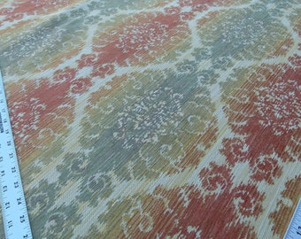 May include: Close-up of a fabric with a repeating pattern of red, orange, green, and white. The pattern is a stylised floral design.