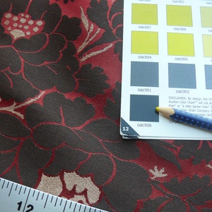 May include: Close-up of a fabric swatch with a floral pattern in shades of red, brown, and beige. A ruler is visible in the bottom left corner. A color chart with the text "Online Auction Color Chart" is visible in the top right corner.